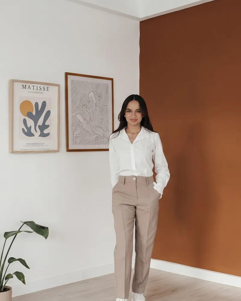 Amanda Oliveira sorrindo em seu escritório de consultoria e recrutamento
